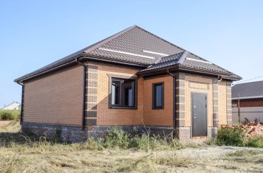 Plastik pencere ve oluklu levha çatısı olan ev. Çatı metal profil dalgalı şeklin üzerinde plastik penceresi olan ev.