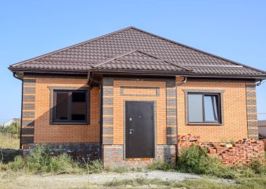 Plastik pencere ve oluklu levha bir çatı ile ev