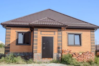 Plastik pencere ve oluklu levha çatısı olan ev. Çatı metal profil dalgalı şeklin üzerinde plastik penceresi olan ev.