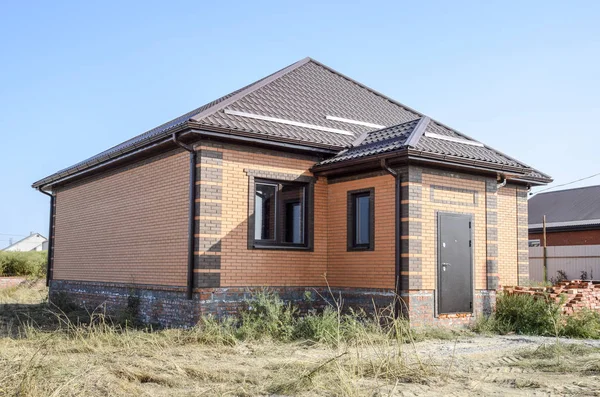 Plastik pencere ve oluklu levha çatısı olan ev. Çatı metal profil dalgalı şeklin üzerinde plastik penceresi olan ev.