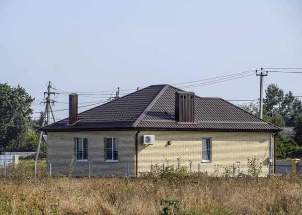 Plastik pencere ve oluklu levha çatısı olan ev. Çatı metal profil dalgalı şeklin üzerinde plastik penceresi olan ev.