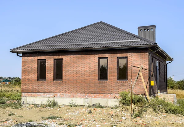茶色の屋根と茶色の煉瓦 プラスチック製の窓と波板の屋根を持つ家 プラスチック製の窓が付いている家の波状形状金属の屋根ふき — ストック写真