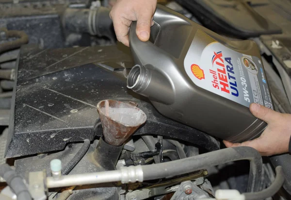 Otomobilin motor yağ değişimi. Huni yağ doldurma. Araba bakım istasyonu.