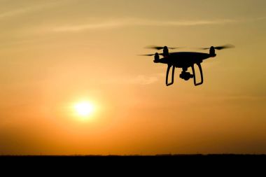 Quadrocopters siluet güneşin arka planı