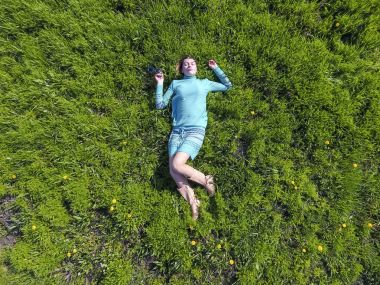 ' In bahçesinde turkuaz elbiseli bir kız yatıyor. otların uzanmış güzel kız