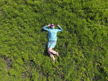 ' In bahçesinde turkuaz elbiseli bir kız yatıyor. otların uzanmış güzel kız