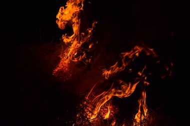 Pirinç saman geceleri yanan. Siyah bir zemin üzerine kırmızı ateş. Yanma.