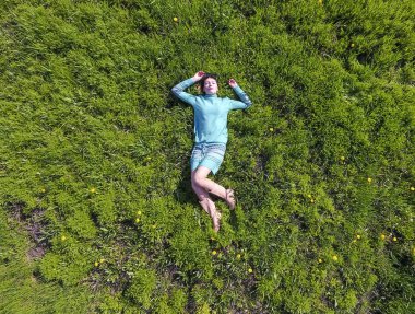 ' In bahçesinde turkuaz elbiseli bir kız yatıyor. otların uzanmış güzel kız