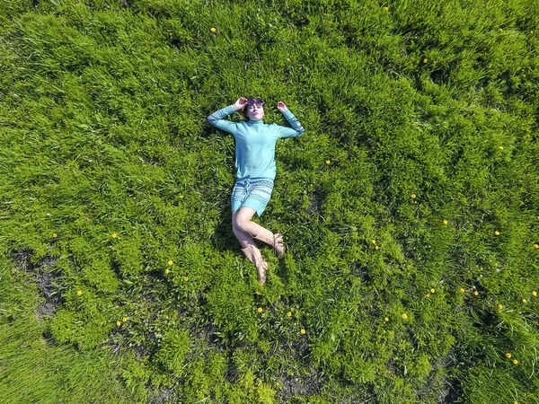 ' In bahçesinde turkuaz elbiseli bir kız yatıyor. otların uzanmış güzel kız