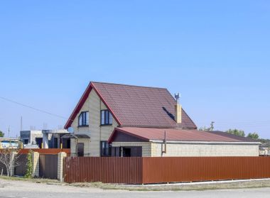 Plastik pencere ve oluklu levha çatısı olan ev. Çatı metal profil dalgalı şeklin üzerinde plastik penceresi olan ev