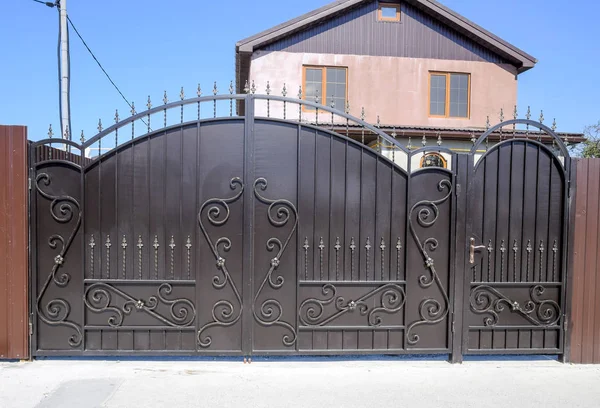 House with a fence and gates. View of a new built-up fence and a house — Stock Photo, Image