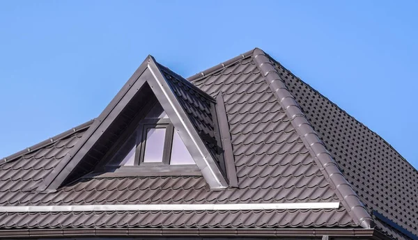 Дом с пластиковыми окнами и коричневой крышей из гофрированного листа — стоковое фото