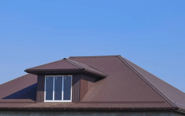 Casa com janelas de plástico e um telhado marrom de folha ondulada — Fotografia de Stock
