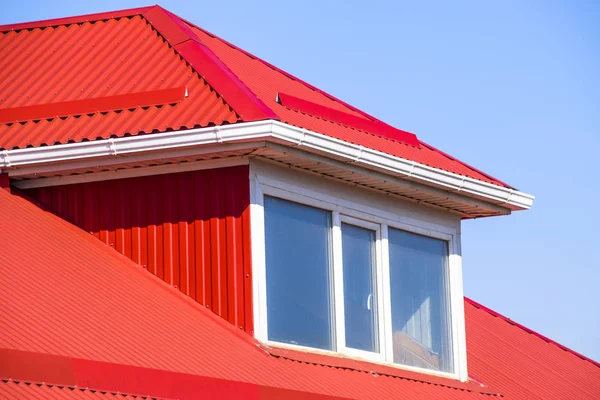 Дом с пластиковыми окнами и красной крышей из гофрированного листа — стоковое фото