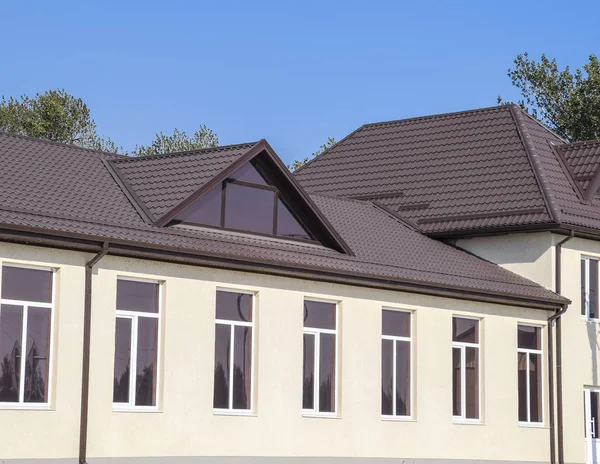 Дом с пластиковыми окнами и крышей из гофрированного листа. Крыша металлического профиля волнистой формы на доме с пластиковыми окнами — стоковое фото