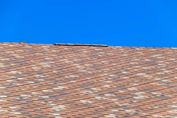 Roof from multi-colored bituminous shingles. Patterned bitumen shingles. — Stock Photo, Image