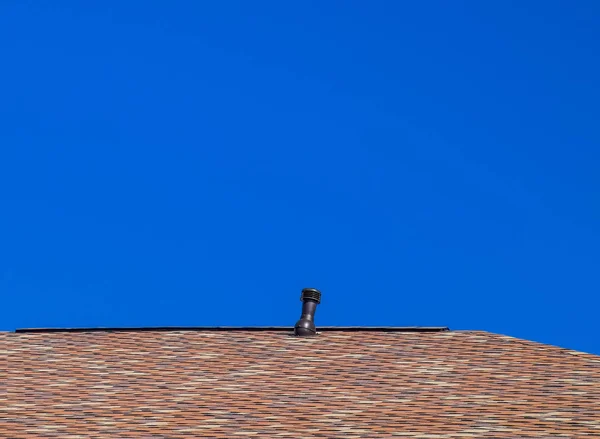 Techo de tejas bituminosas multicolores. Tejas de betún modeladas. Ventilación en el techo . —  Fotos de Stock