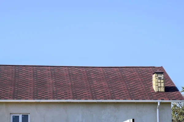 Dach aus mehrfarbigen Bitumenschindeln. gemusterte Bitumenschindeln. Bituminöses Burgunderdach. — Stockfoto