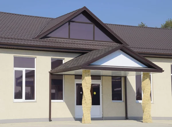 Building with a brown roof. The main entrance to the house. Modern materials of finish and roofing. — Stock Photo, Image