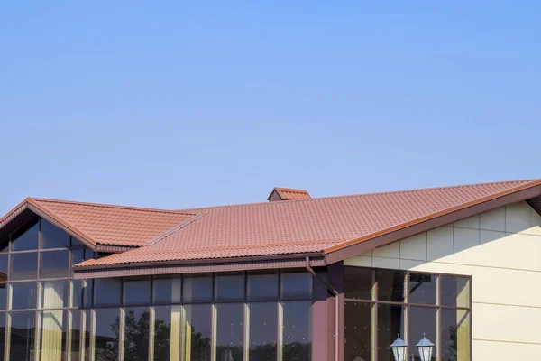 Building with yellow walls and a red-brown roof. Modern materials of finish and roofing. — Stock Photo, Image