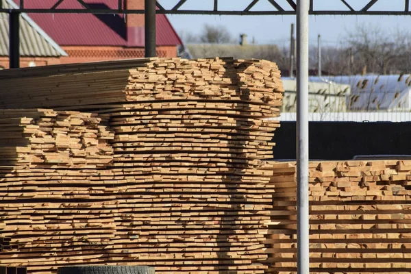 Lager för byggmaterial, trä plankor staplade under en baldakin — Stockfoto