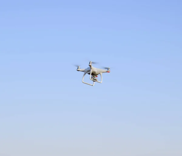 Drone bianco contro il cielo blu della sera. Volo multicopter . — Foto Stock