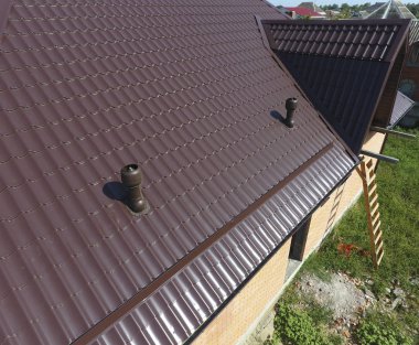 Metal çatı üzerinde hava kanalları. Oluklu levha çatı. Çatı metal profil dalgalı şeklinin
