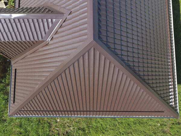 Вид сверху на крышу дома. Крыша из гофрированного листа. Крыша металлического профиля волнистой формы
