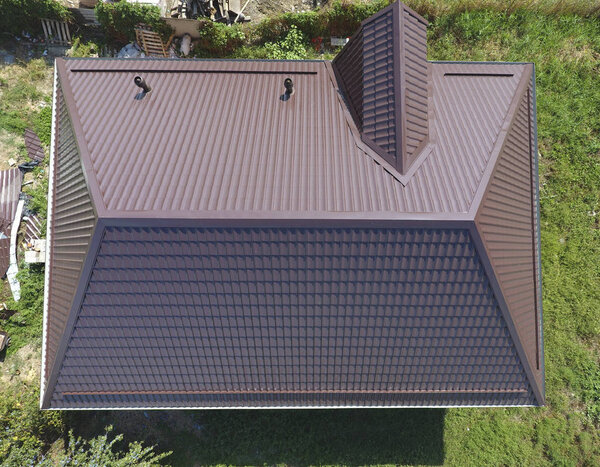 Вид сверху на крышу дома. Крыша из гофрированного листа. Крыша металлического профиля волнистой формы
