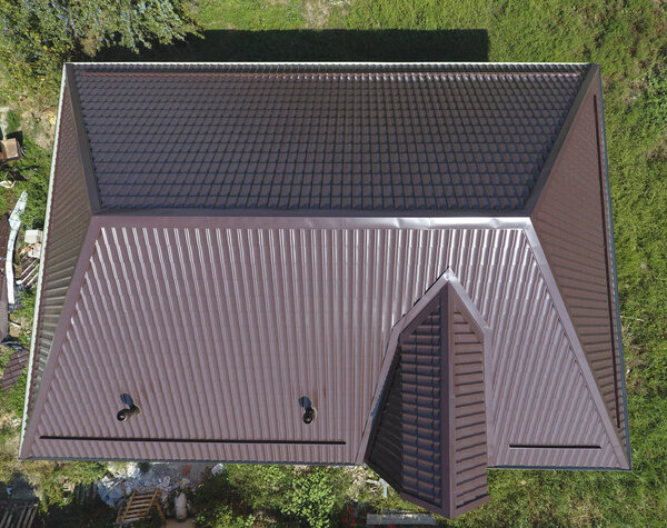 Вид сверху на крышу дома. Крыша из гофрированного листа. Крыша металлического профиля волнистой формы
