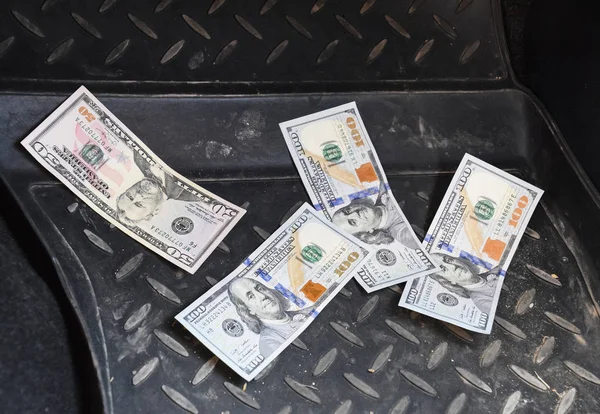 Mehrere Dollarnoten liegen auf der Matte eines Autos — Stockfoto