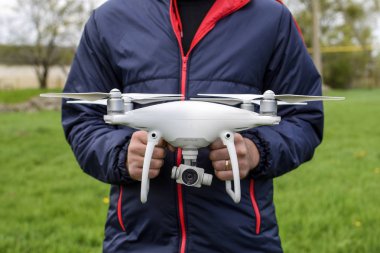 Quadrocopter onun elinde olan bir adam. Beyaz bir dron p ediliyor