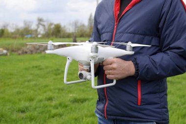 Quadrocopter onun elinde olan bir adam. Beyaz bir dron p ediliyor