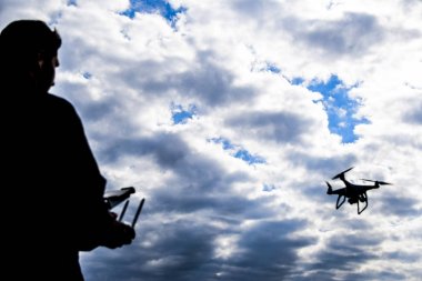 Bir adam elinde bir uzaktan kumanda ile. Gökyüzüne karşı drone uçuş kontrol. Hayalet