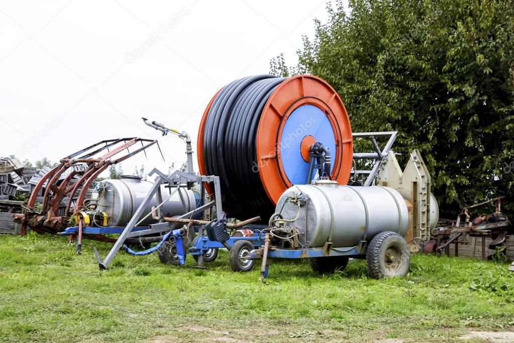 Trailers with fertilizer tanks and a drum with a watering hose.