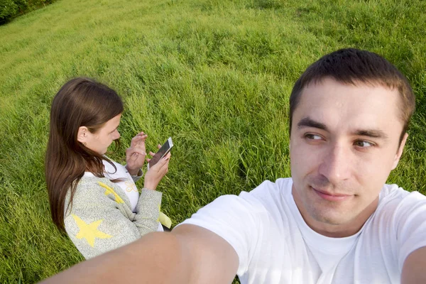 Un hombre con una mujer en un prado. Selfi hace el chico y la chica —  Fotos de Stock