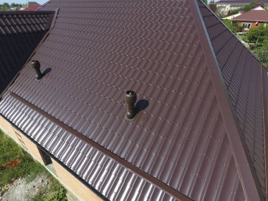 Oluklu levha çatı. Çatı metal profil dalgalı şeklin. Hava kanalları metal çatı üzerinde.