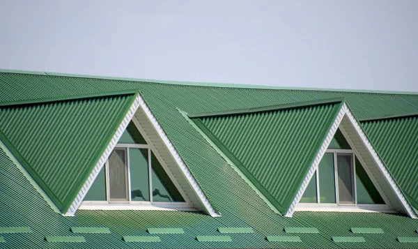Дом с пластиковыми окнами и зеленой крышей из гофрированного ш — стоковое фото