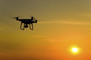Quadrocopters siluet güneşin arka planı. Akşam gökyüzünde uçan uçaklar.