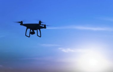 Quadrocopters siluet güneşin arka planı. Akşam gökyüzünde uçan uçaklar.