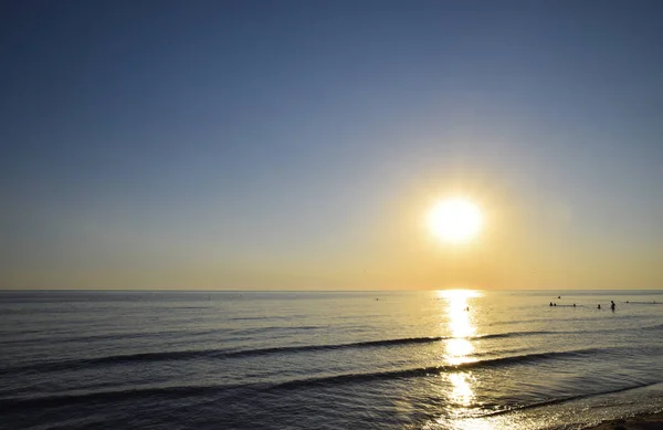 Sea sunset. People bathe in the evening at sunset in the sea