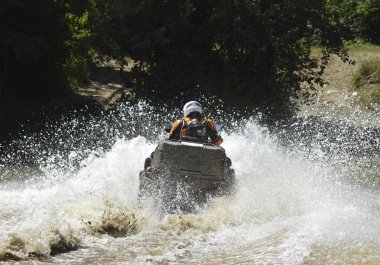 ATV 'deki adam dereyi geçiyor. Turist ülkeyi boydan boya geziyor..