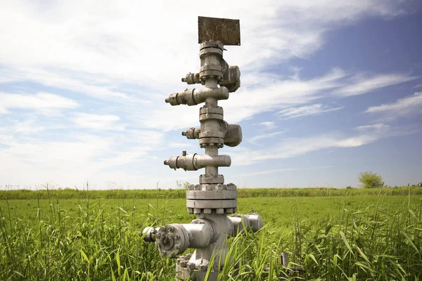 Canned oil well against the sky and field Stock Picture