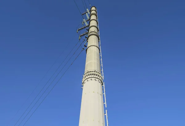 Yüksek voltajlı elektrik hatları mavi gökyüzü destekler — Stok fotoğraf