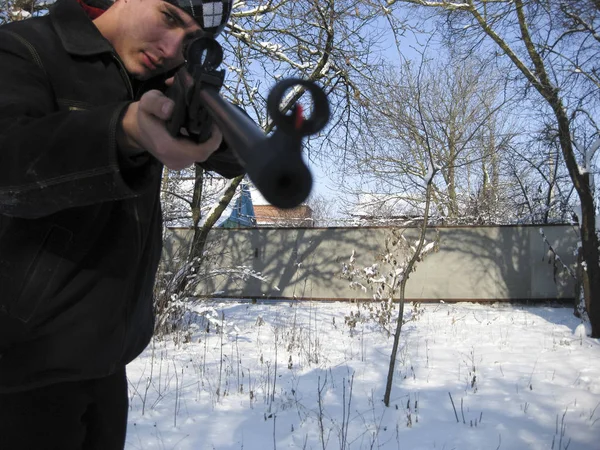 Man med ett luftgevär i en winter park. — Stockfoto