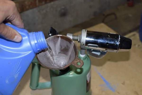 Pouring gasoline blowtorch through the funnel — Stock Photo, Image