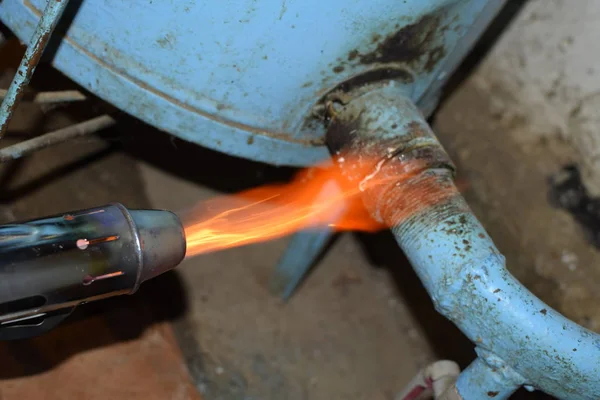 Θέρμανση ενός σωλήνα χάλυβα με ένα καμινέτο. Η φλόγα ενός καμινέτου — Φωτογραφία Αρχείου
