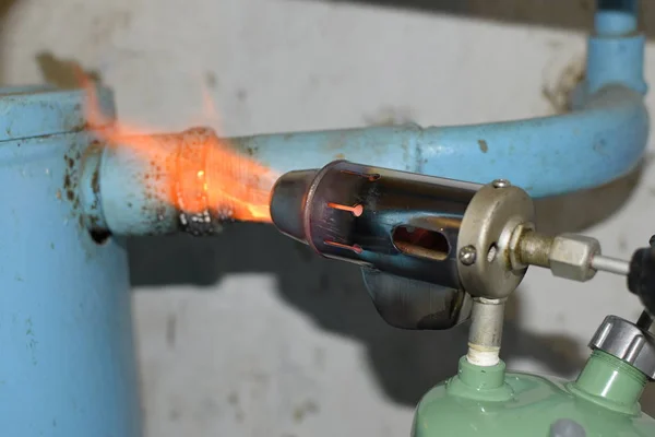 Aquecimento de um tubo de aço com um maçarico. A chama de um maçarico — Fotografia de Stock