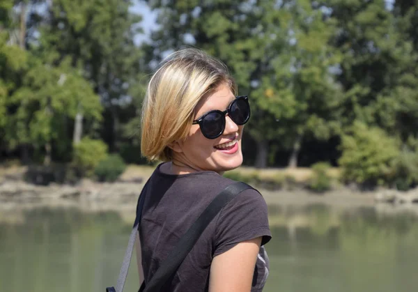 Genç güzel kız nehir manzara, portre sarışın arka planı güneş gözlüğü