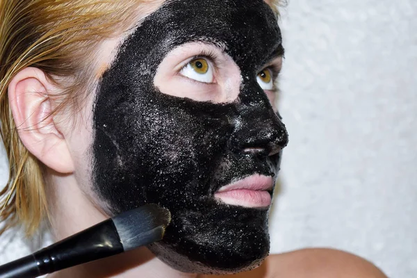 Девушка в косметической черной маске. Очищающая маска аспирина и активированного угля. Черная косметическая маска . — стоковое фото